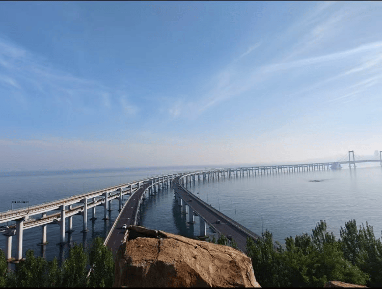 大连一跨海大桥观景台有游客翻栏杆踩空心造景石拍照，当地回应